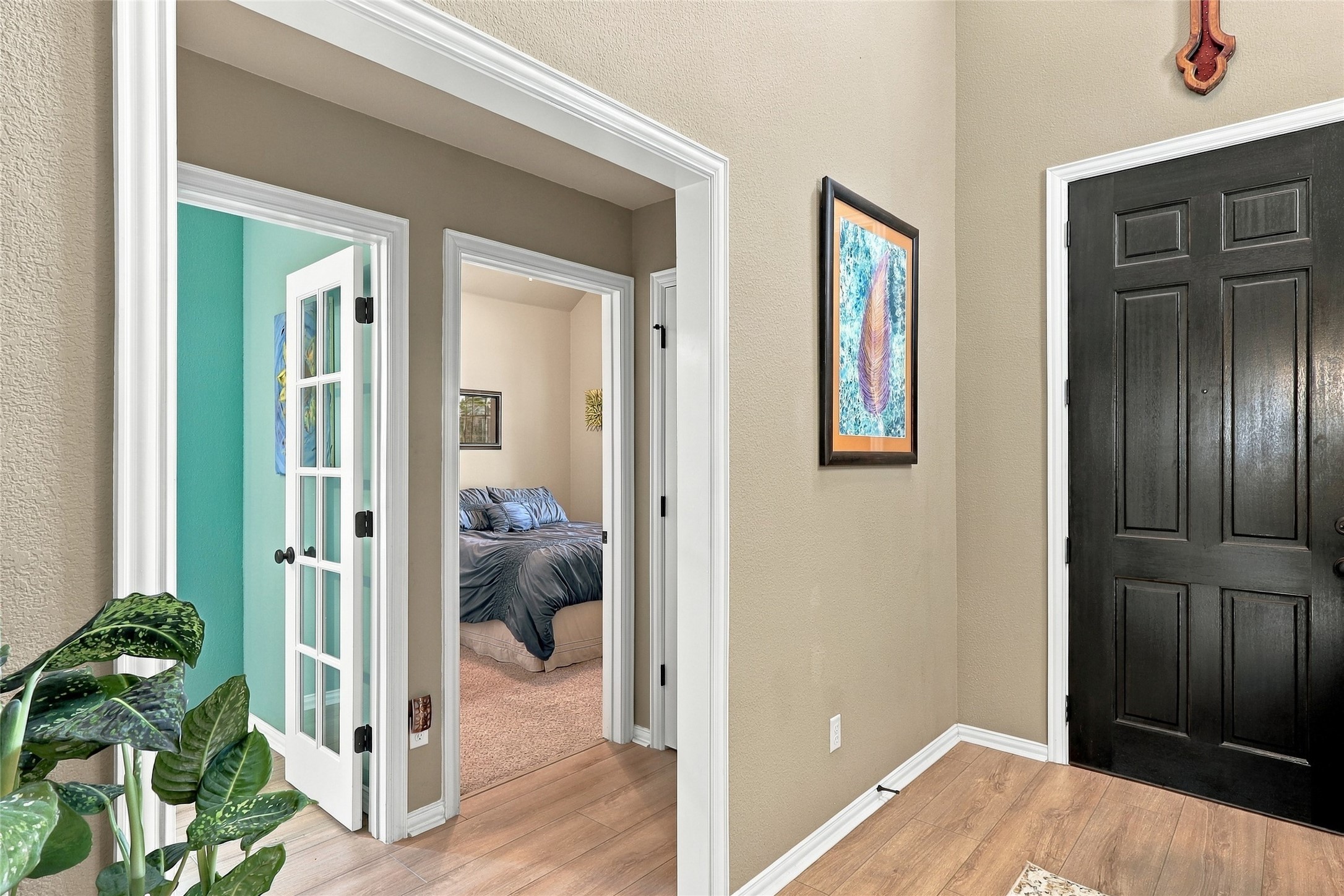 320 Fort Cobb Way Georgetown, TX 78628 - Photo 2 of 37 Crisp white trim frames the doorways in a welcoming entryway featuring wood floors.
