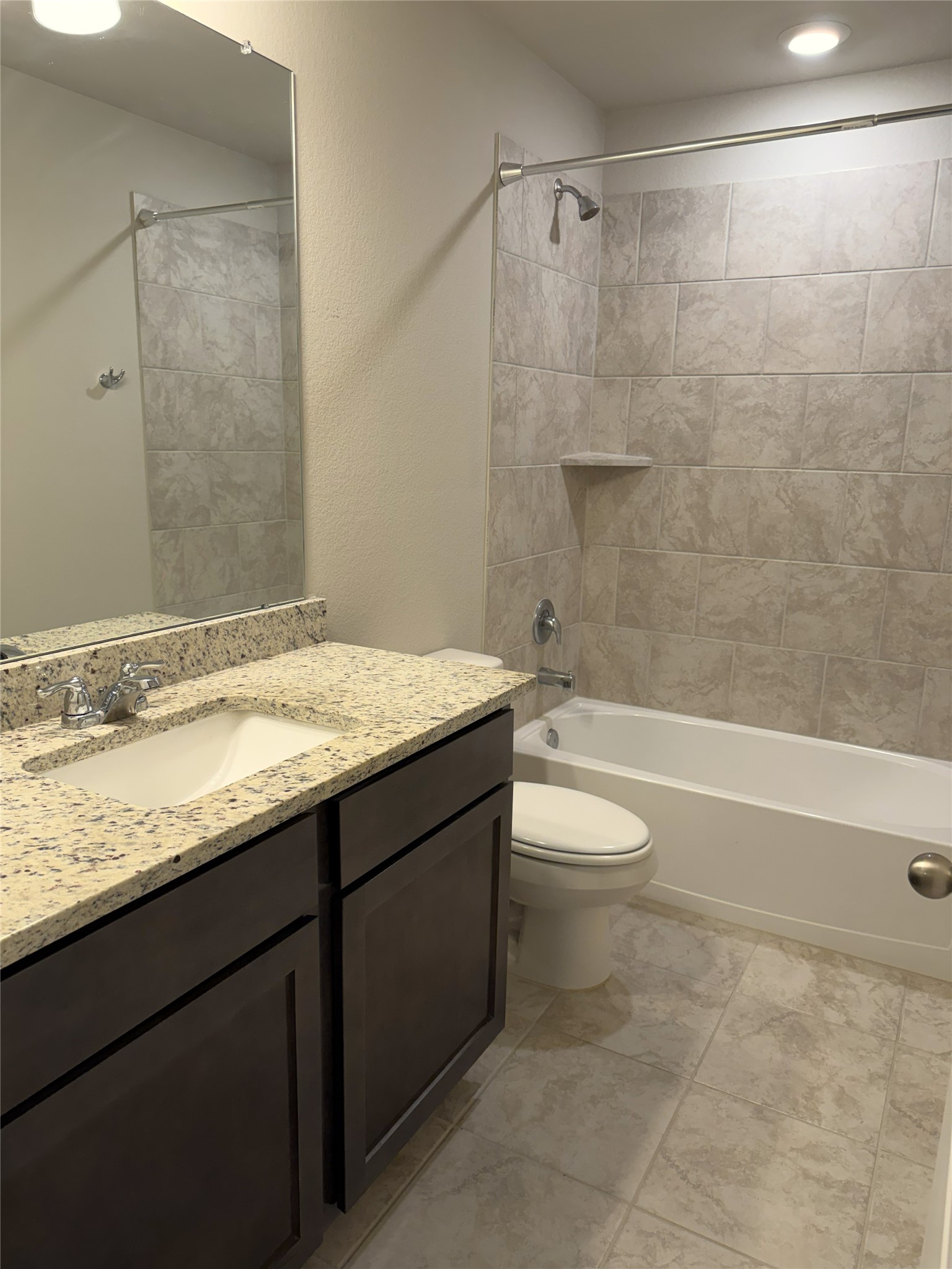 610 Legrand Street Brenham, TX 77833 - Photo 11 of 14 a bathroom with a granite countertop bathtub shower sink vanity and toilet