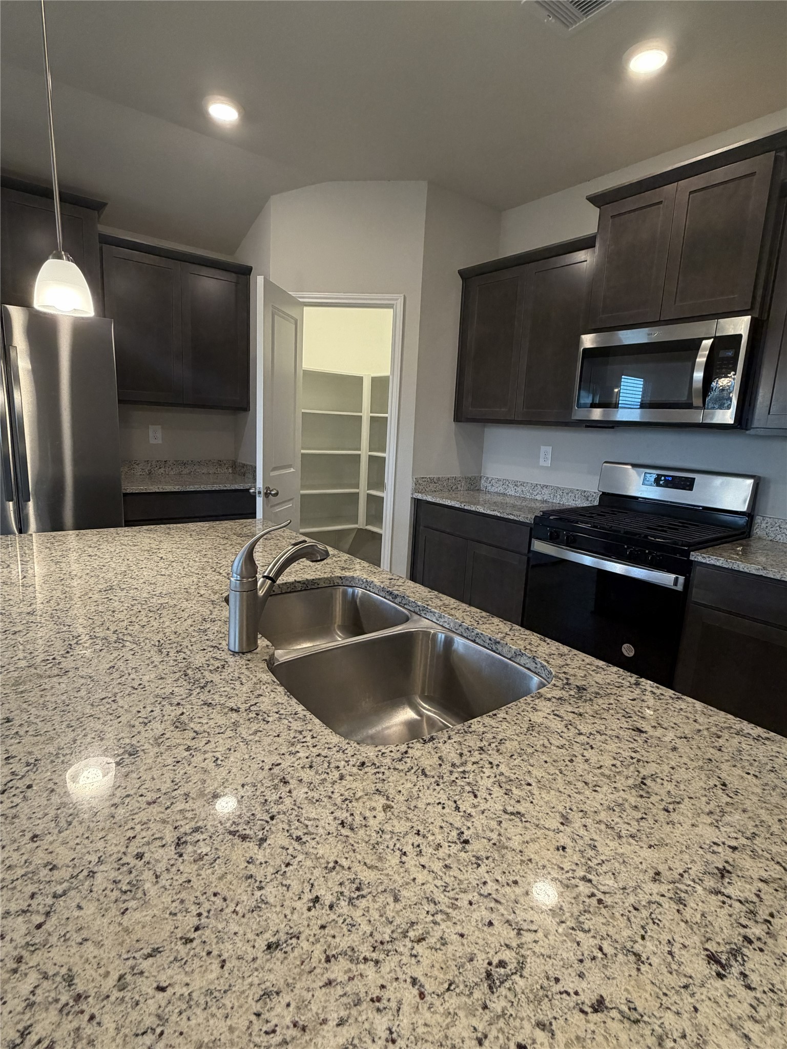 610 Legrand Street Brenham, TX 77833 - Photo 14 of 14 a kitchen with stainless steel appliances a sink a stove a microwave a counter top space and cabinets