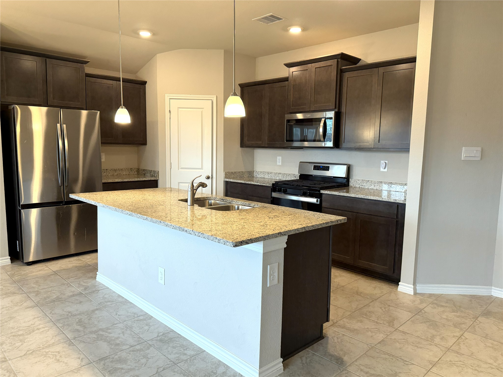 610 Legrand Street Brenham, TX 77833 - Photo 9 of 14 a kitchen with stainless steel appliances granite countertop a sink and a refrigerator