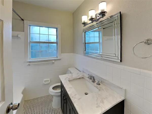a bathroom with a sink vanity and a toilet