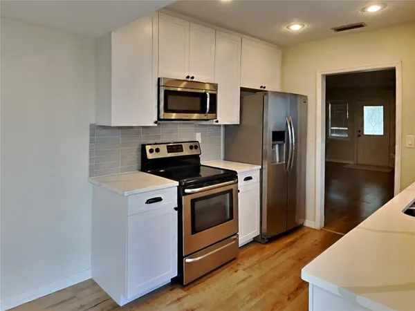 a kitchen with stainless steel appliances a refrigerator a stove a microwave and cabinets