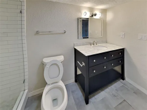 a bathroom with a toilet sink vanity and mirror