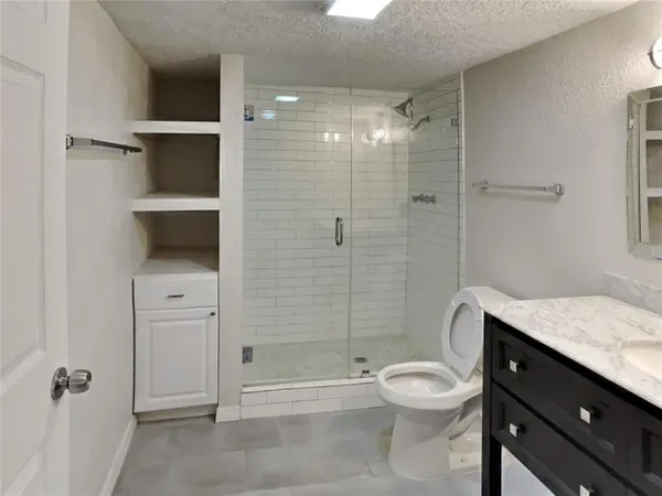 a bathroom with a toilet a sink and shower