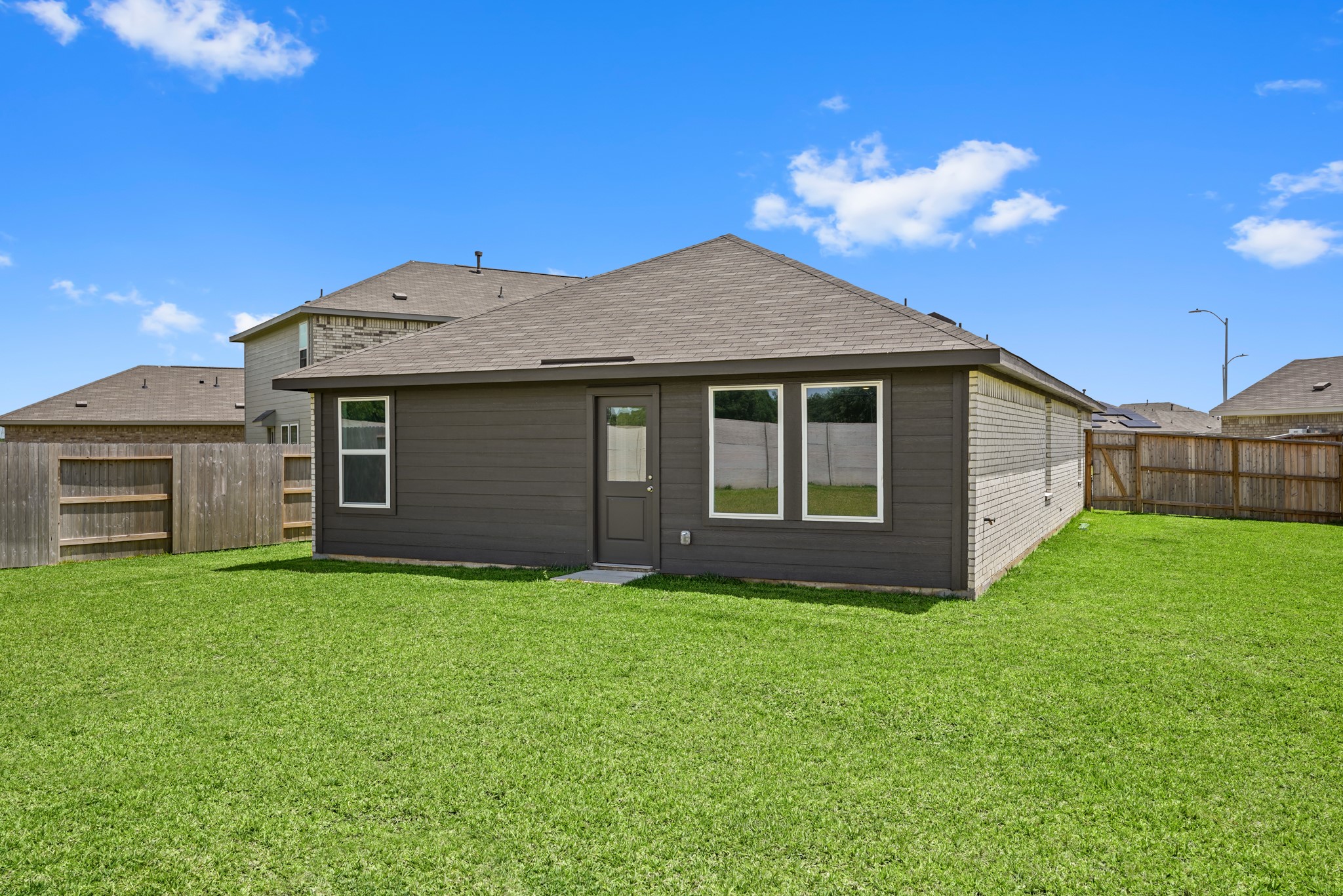 26931 Feather Reed Drive Katy, TX 77493 - Photo 13 of 16 The spacious backyard features a functional green grass lawn, a professional sprinkler system, and showcases the rear elevation of the home.