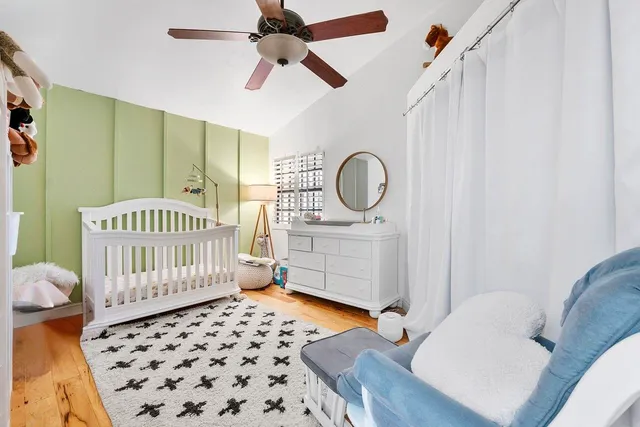 a view of a white house with a big yard plants and large trees