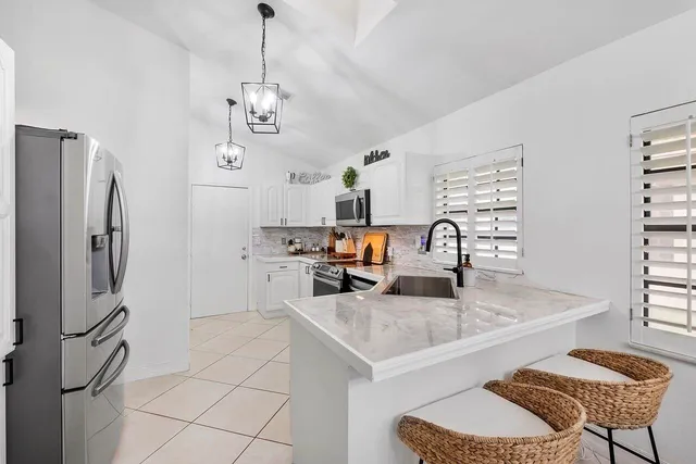 a kitchen with stainless steel appliances granite countertop a refrigerator and a stove top oven