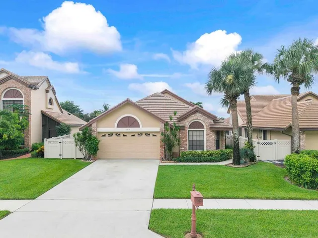 a living room with furniture a flat screen tv and kitchen view