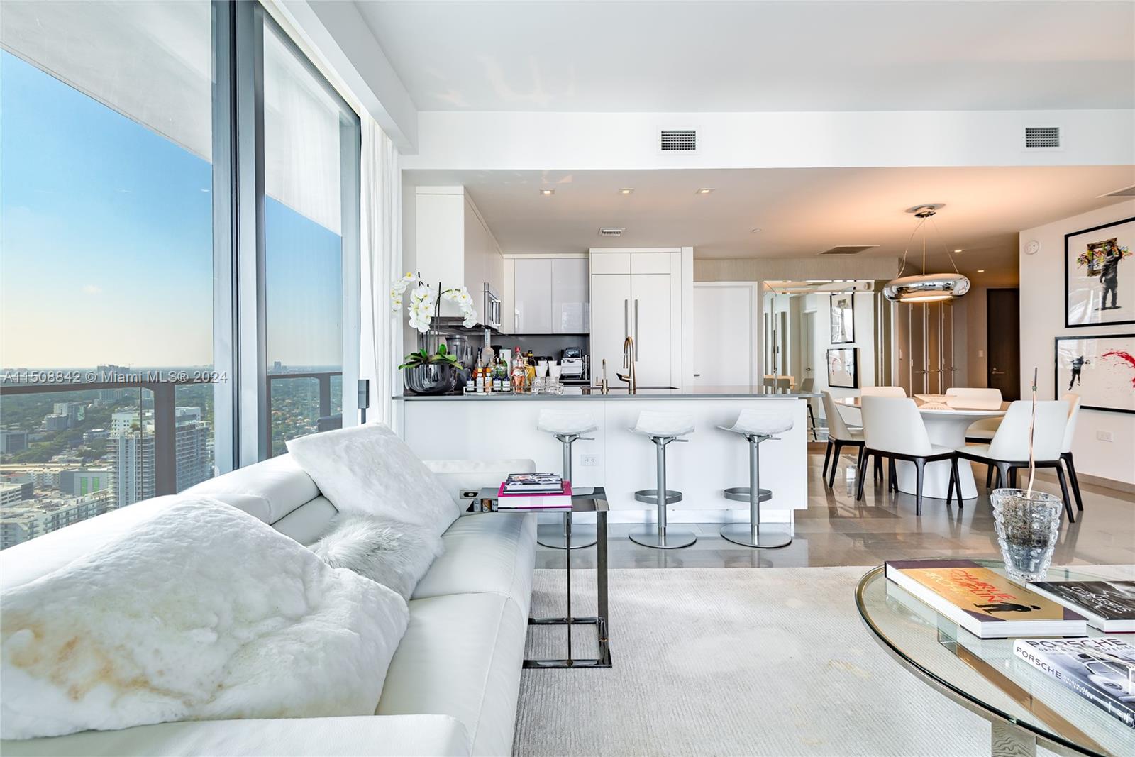 88 Southwest 7th Street, Unit 3301 Miami, FL 33130 - Photo 13 of 54 a living room with furniture and a dining table with kitchen view