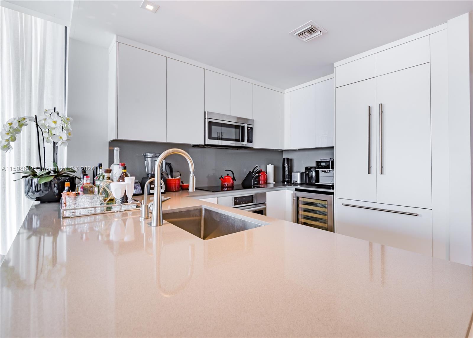 88 Southwest 7th Street, Unit 3301 Miami, FL 33130 - Photo 16 of 54 a kitchen with granite countertop a refrigerator and a sink