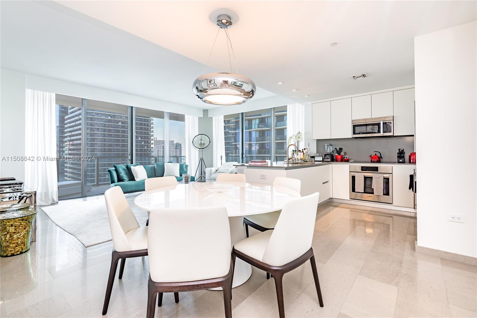 88 Southwest 7th Street, Unit 3301 Miami, FL 33130 - Photo 2 of 54 a kitchen with kitchen island a dining table and chairs