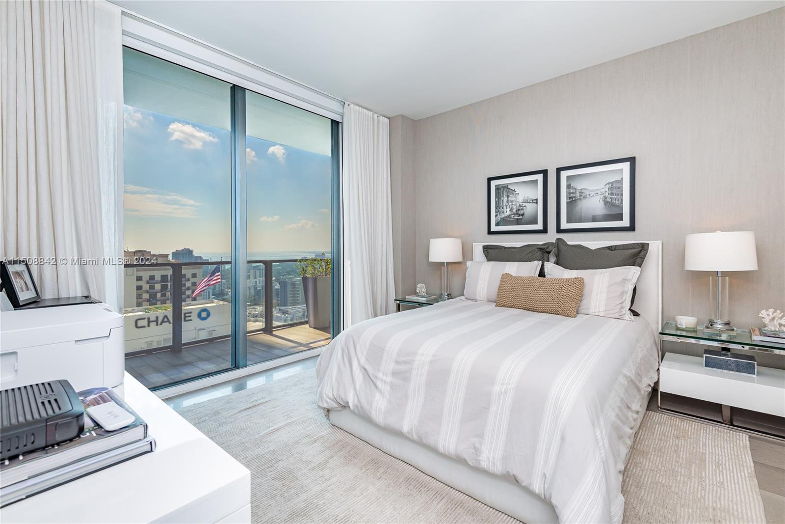 88 Southwest 7th Street, Unit 3301 Miami, FL 33130 - Photo 28 of 54 a spacious bedroom with a bed a table and painting on the wall