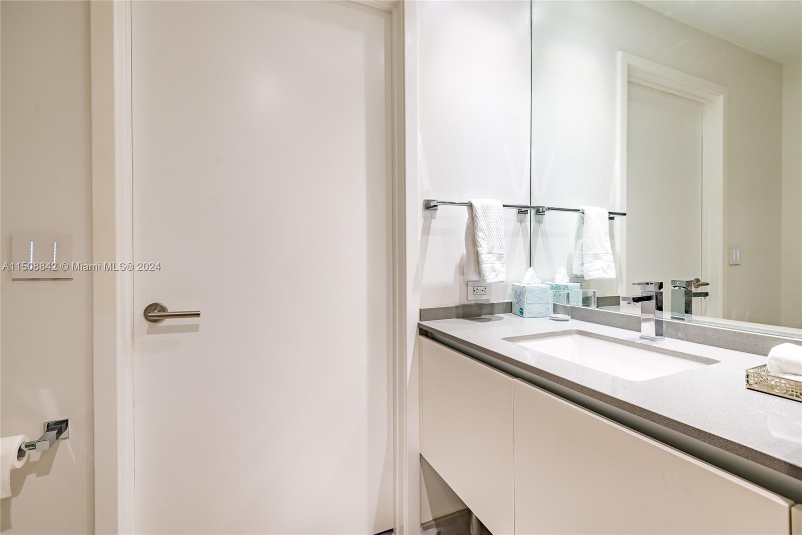 88 Southwest 7th Street, Unit 3301 Miami, FL 33130 - Photo 32 of 54 a bathroom with a sink and a mirror