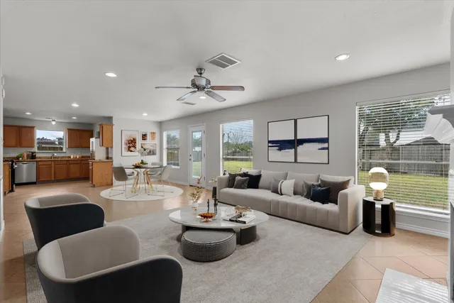 a living room with couches a dining table and kitchen view with wooden floor