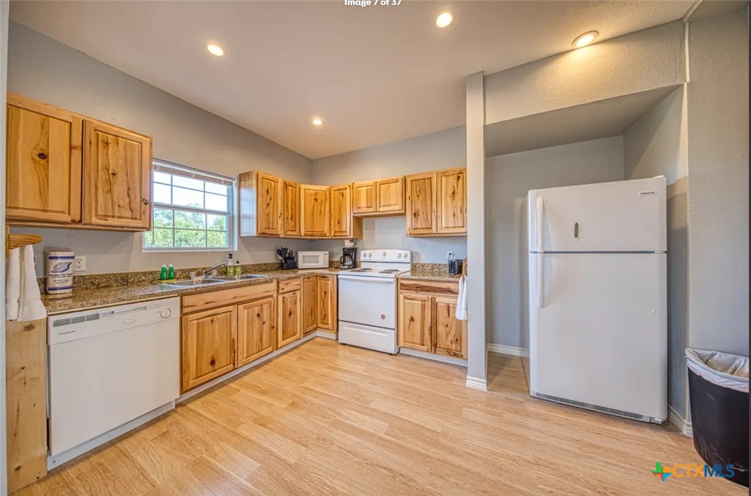 729 Clay Ridge Canyon Lake, TX 78133 - Photo 4 of 13 a kitchen with white cabinets and wooden floor