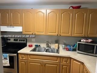 3253 Foxcroft Road, Unit G107 Miramar, FL 33025 - Photo 6 of 11 a kitchen with stainless steel appliances granite countertop a sink a stove and cabinets