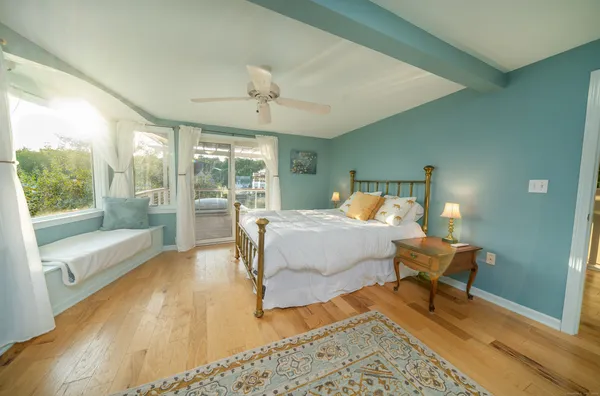a view of a livingroom with a dinning area hardwood floor and a ceiling fan