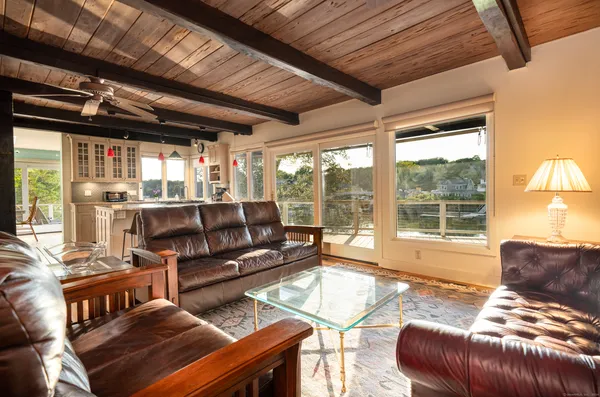a dining room with stainless steel appliances granite countertop a stove a kitchen island with chairs and wooden floor
