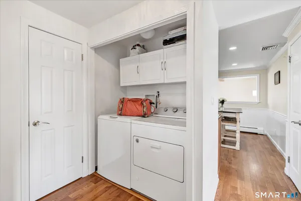 a kitchen with white cabinets and wooden floor
