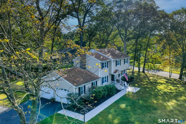 a view of a big house in front of a big yard with large trees