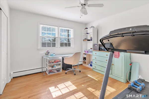 a view of a workspace with furniture and a gym machine