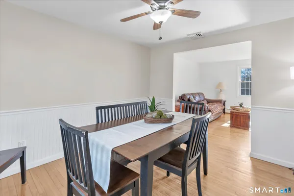 a view of a dining room and livingroom with furniture wooden floor a chandelier