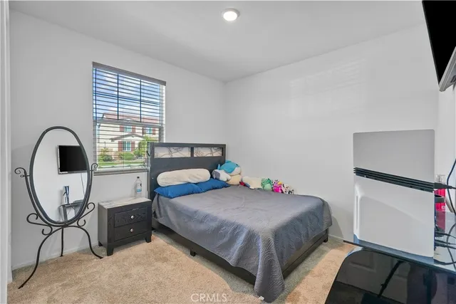 a bedroom with a bed a desk and a window