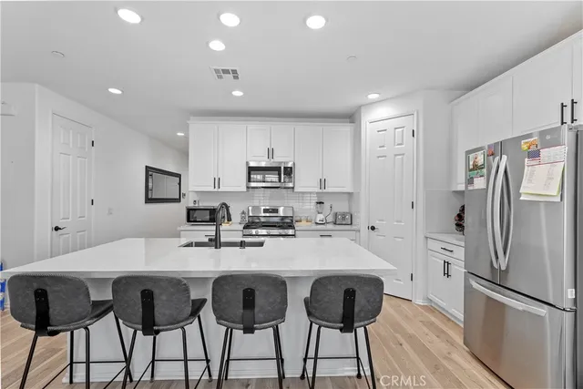 a kitchen with refrigerator and chairs