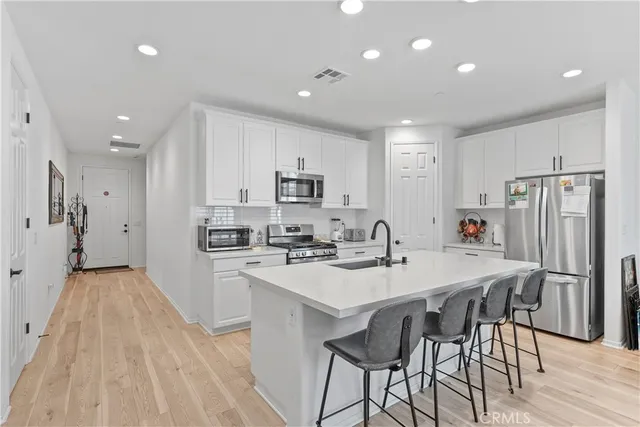 a kitchen with appliances a sink and a refrigerator
