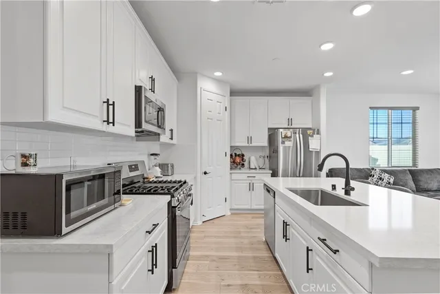 a kitchen with stainless steel appliances granite countertop a sink stove and cabinets