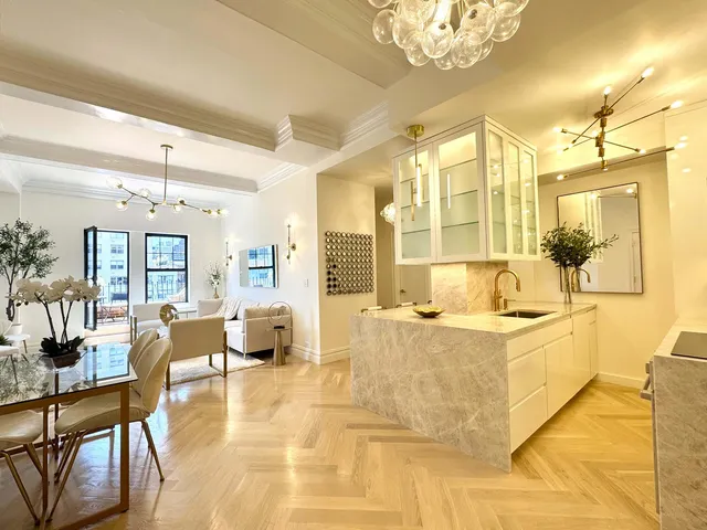 a large white kitchen with a large window and stainless steel appliances