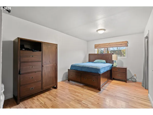 a bedroom with a bed and wooden floor