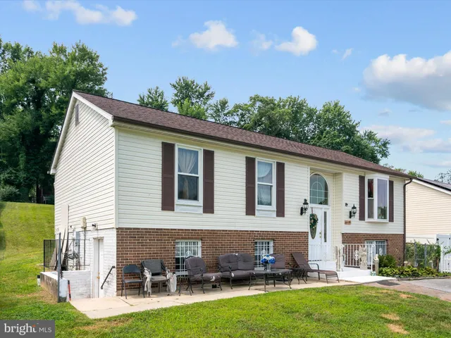a view of a house with a yard and sitting area
