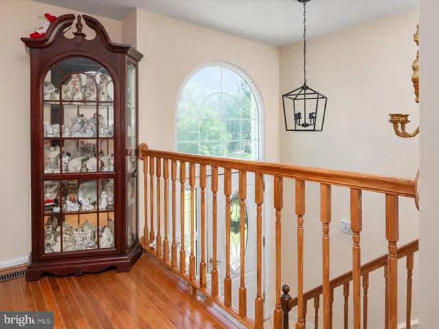 a view of wooden floor a chandelier and entryway