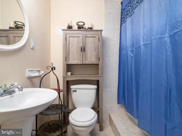 a bathroom with a toilet a sink and a mirror
