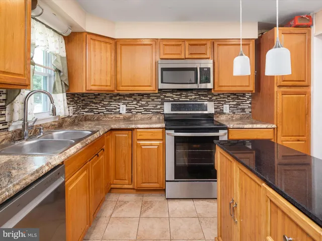 a kitchen with granite countertop a stove sink and microwave