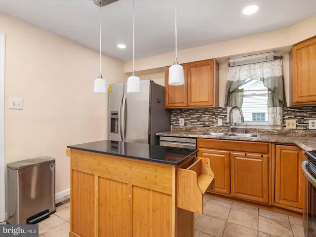 a kitchen with stainless steel appliances granite countertop a sink and a refrigerator