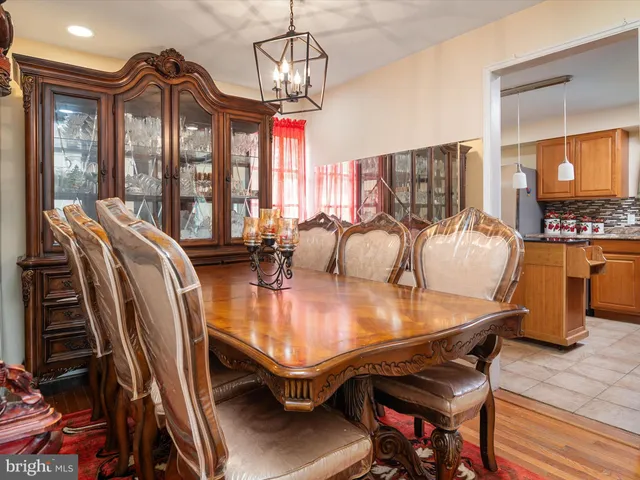 a dining room with furniture a chandelier and wooden floor