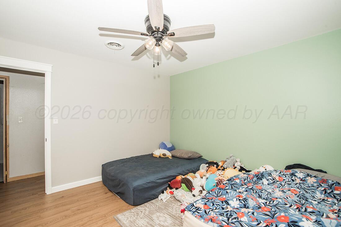 3609 Patterson Drive Amarillo, TX 79109 - Photo 14 of 21 a bedroom with a bed and wooden floor