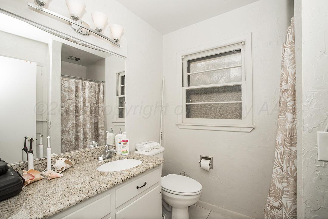 3609 Patterson Drive Amarillo, TX 79109 - Photo 18 of 21 a bathroom with a granite countertop sink vanity mirror and toilet