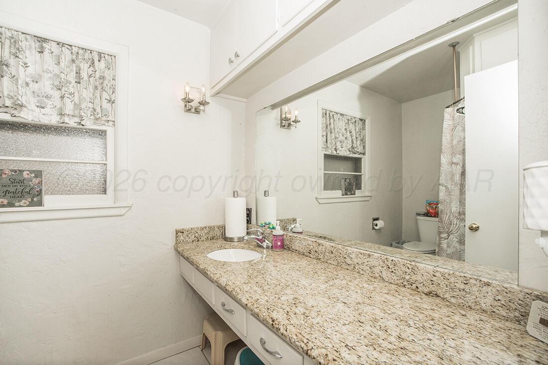 3609 Patterson Drive Amarillo, TX 79109 - Photo 20 of 21 a bathroom with a granite countertop sink and a mirror