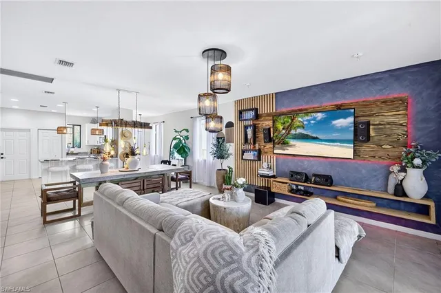 a living room with furniture kitchen view and a large window