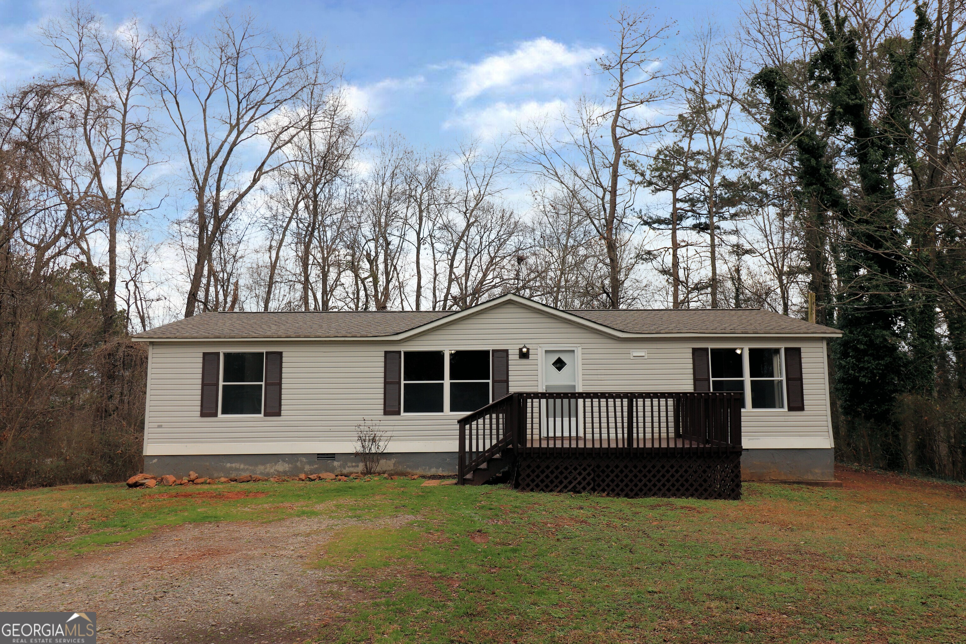 a view of a house with a big yard and large tree
