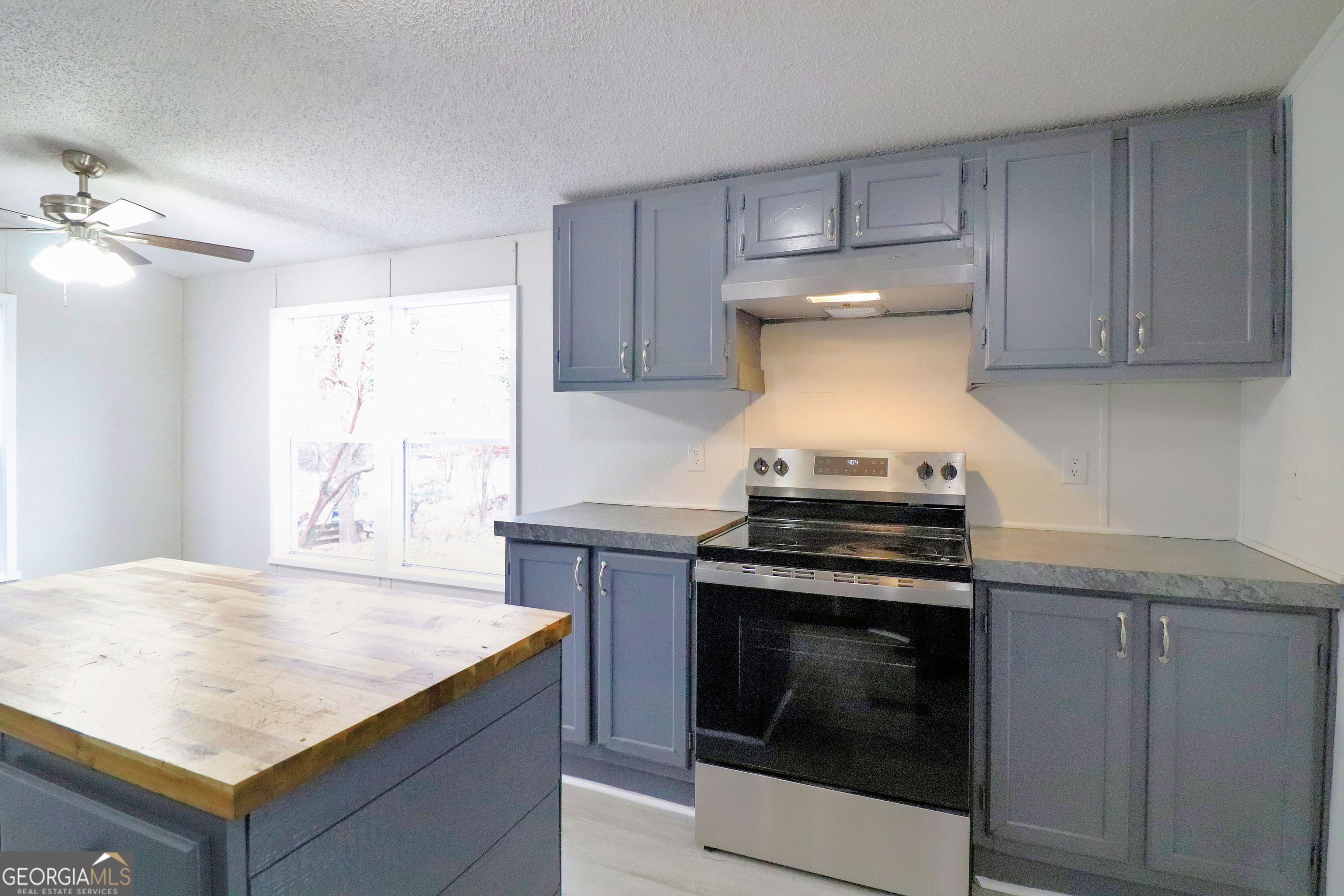2200 Ridgeside Drive Villa Rica, GA 30180 - Photo 11 of 32 a kitchen with granite countertop a stove sink and cabinets