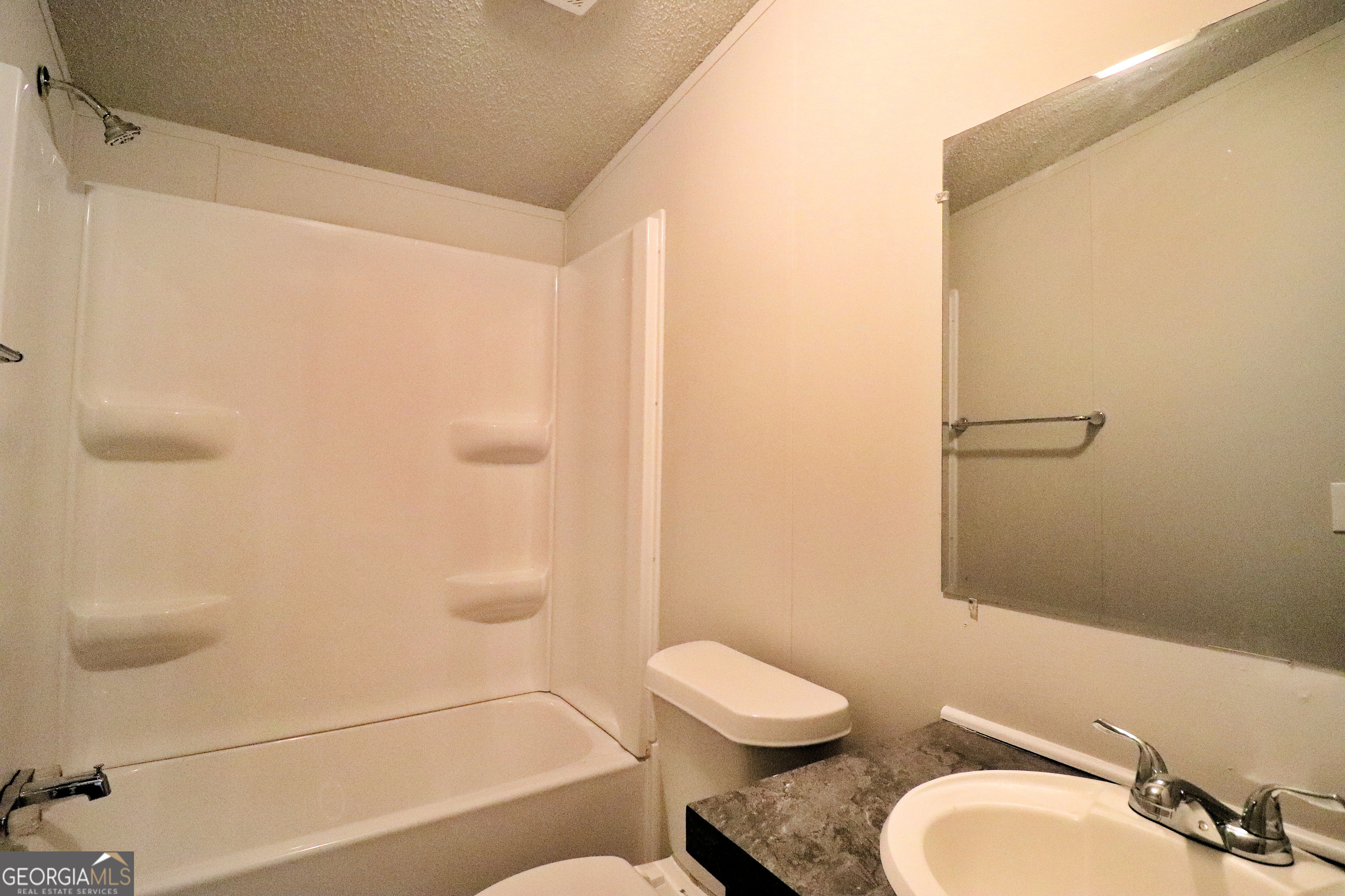 2200 Ridgeside Drive Villa Rica, GA 30180 - Photo 31 of 32 a bathroom with a granite countertop toilet a sink and a shower