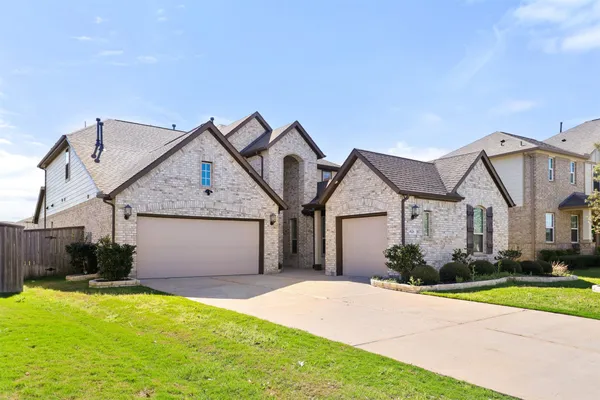 a front view of a house with a garden and yard