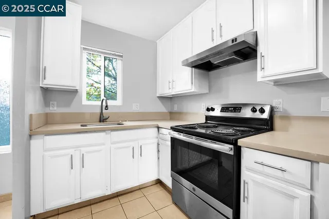 a kitchen with white cabinets stainless steel appliances and sink