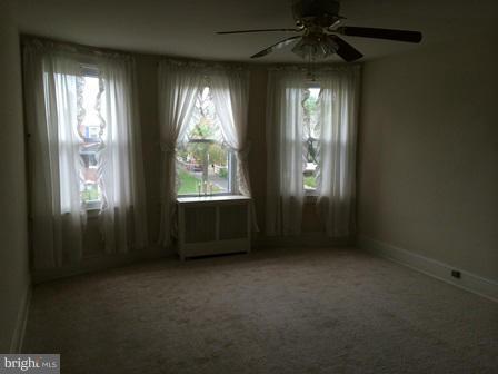 602 Brookwood Road Baltimore, MD 21229 - Photo 4 of 7 an empty room with windows and chandelier fan