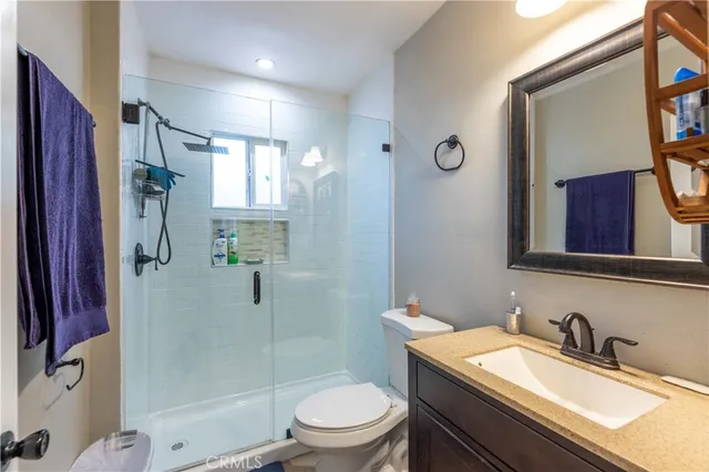 a bathroom with a granite countertop sink toilet and shower