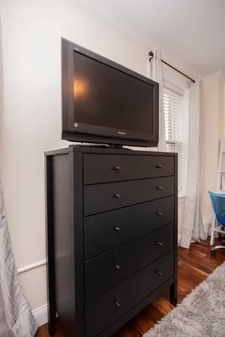 a room with wooden floor and flat screen tv